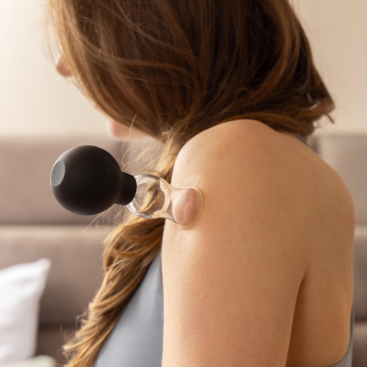 BACKLAXX Schröpfglas-Anwendung auf der Schulter - Transparenter Saugnapf mit schwarzem Gummiball zur gezielten Entspannung von Schulter- und Nackenverspannungen
