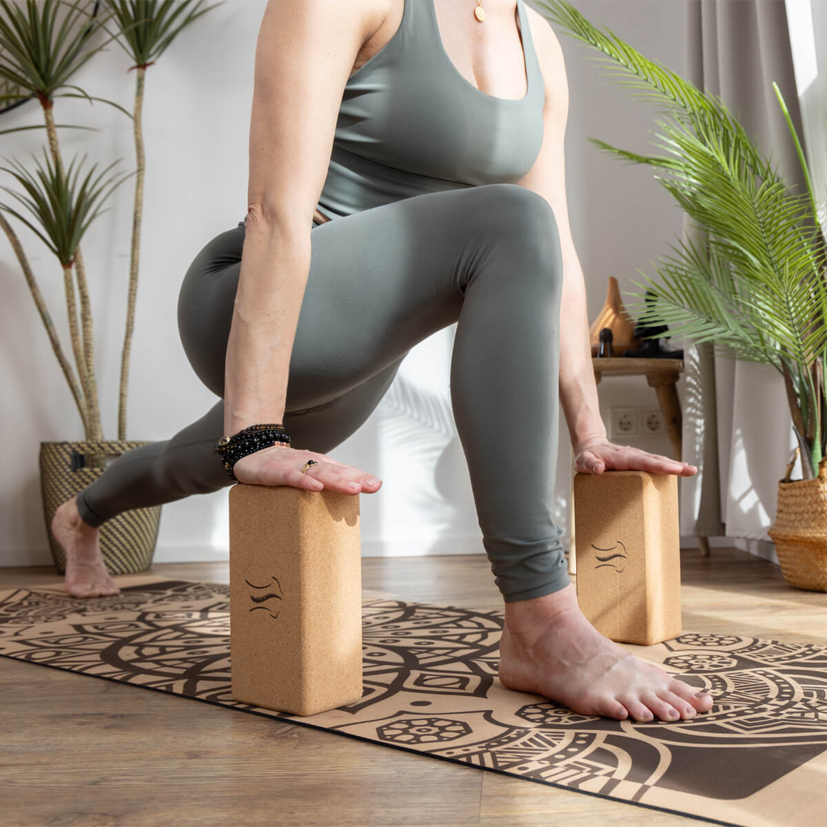 Frau in Yogapose mit Yogablöcken auf Yogamatte