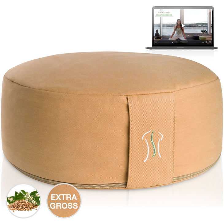 Rundes Kissen apricotgelb mit Naht, neben einem Laptop mit Yoga-Video
