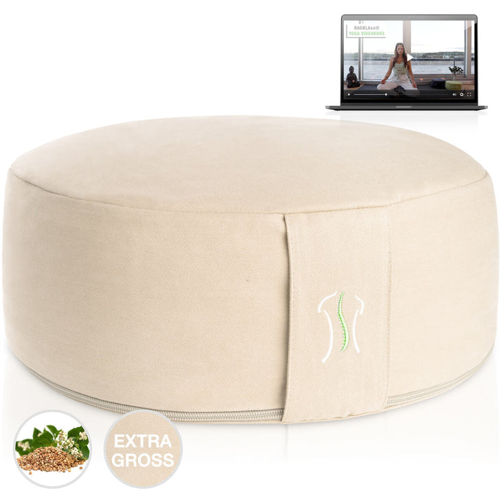 Rundes Kissen naturfarben mit Naht, neben einem Laptop mit Yoga-Video
